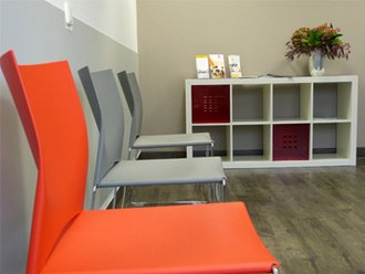 Stühle im Vordergrund eines Wartezimmers